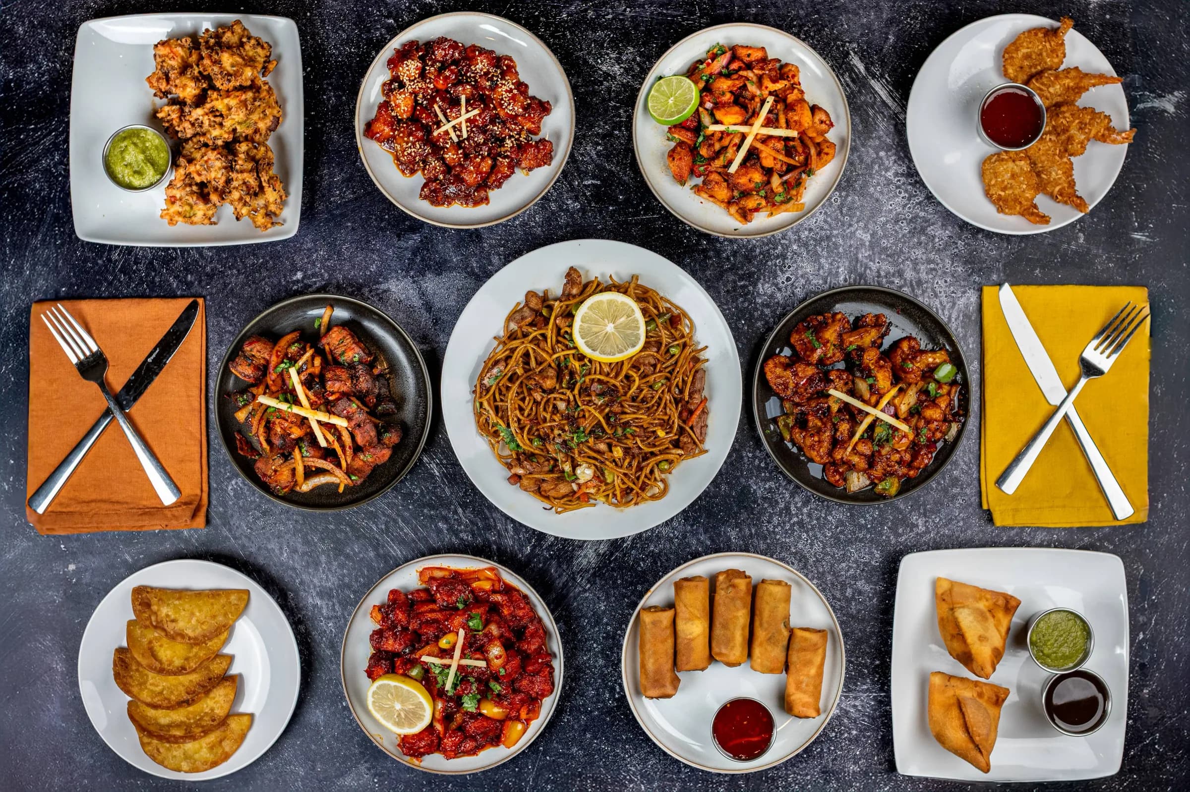 Spread of appetizers, noodles and curries